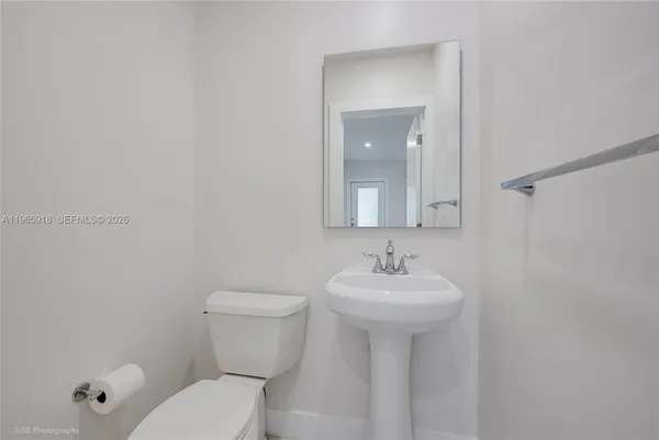 a bathroom with a sink toilet and mirror