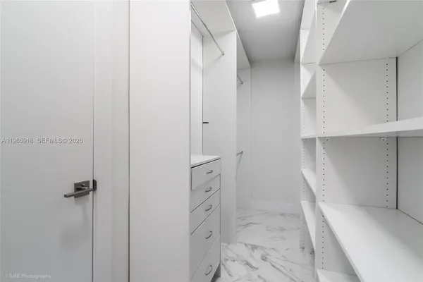 a view of walk in closet with empty racks