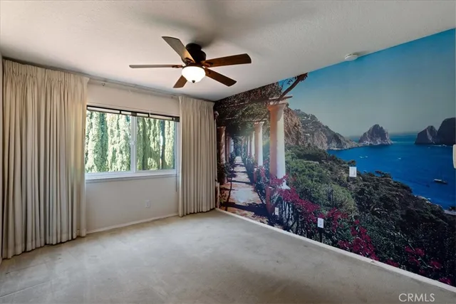 a view of a livingroom with a ceiling fan and window