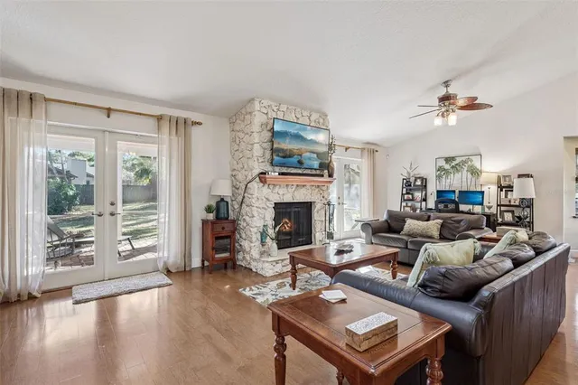 a living room with furniture a fireplace and a floor to ceiling window