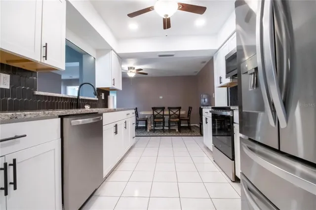 a kitchen with stainless steel appliances granite countertop a stove a sink and a refrigerator