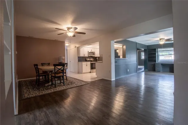 a view of a dining room and livingroom with furniture wooden floor a chandelier