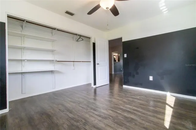 a view of an empty room with a ceiling fan