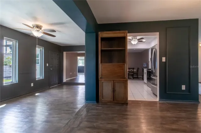 a view of a hallway with wooden floor and a living room