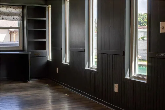 a view of empty room with wooden floor and windows