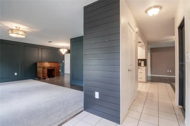 a view of a hallway with furniture and chandelier