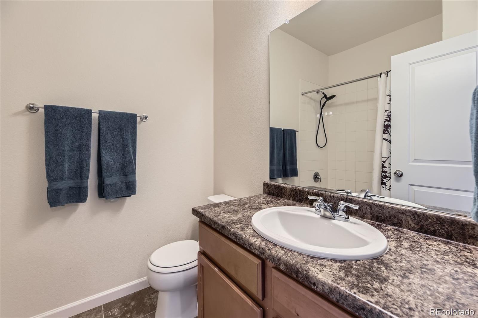 4807 River Highlands Loop Elizabeth, CO 80107 - Photo 13 of 37 a bathroom with a granite countertop sink toilet and mirror