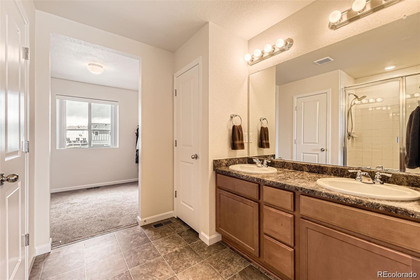 4807 River Highlands Loop Elizabeth, CO 80107 - Photo 16 of 37 a bathroom with a granite countertop sink and a mirror