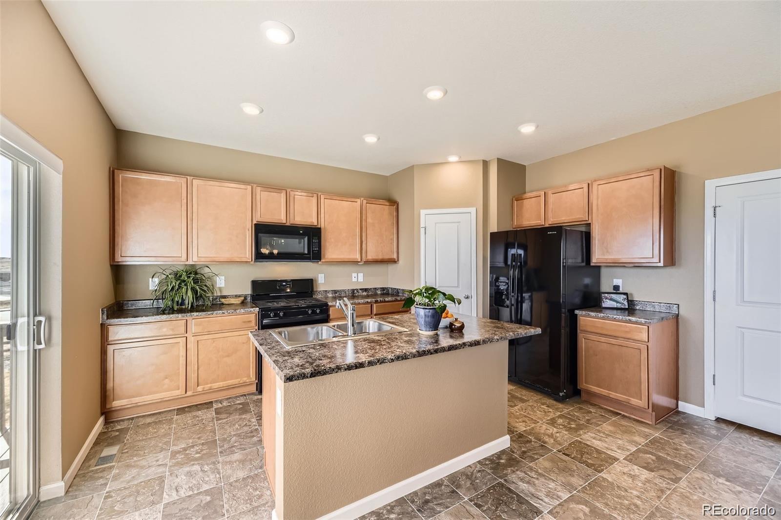 4807 River Highlands Loop Elizabeth, CO 80107 - Photo 4 of 37 a kitchen with stainless steel appliances granite countertop a refrigerator stove microwave and sink