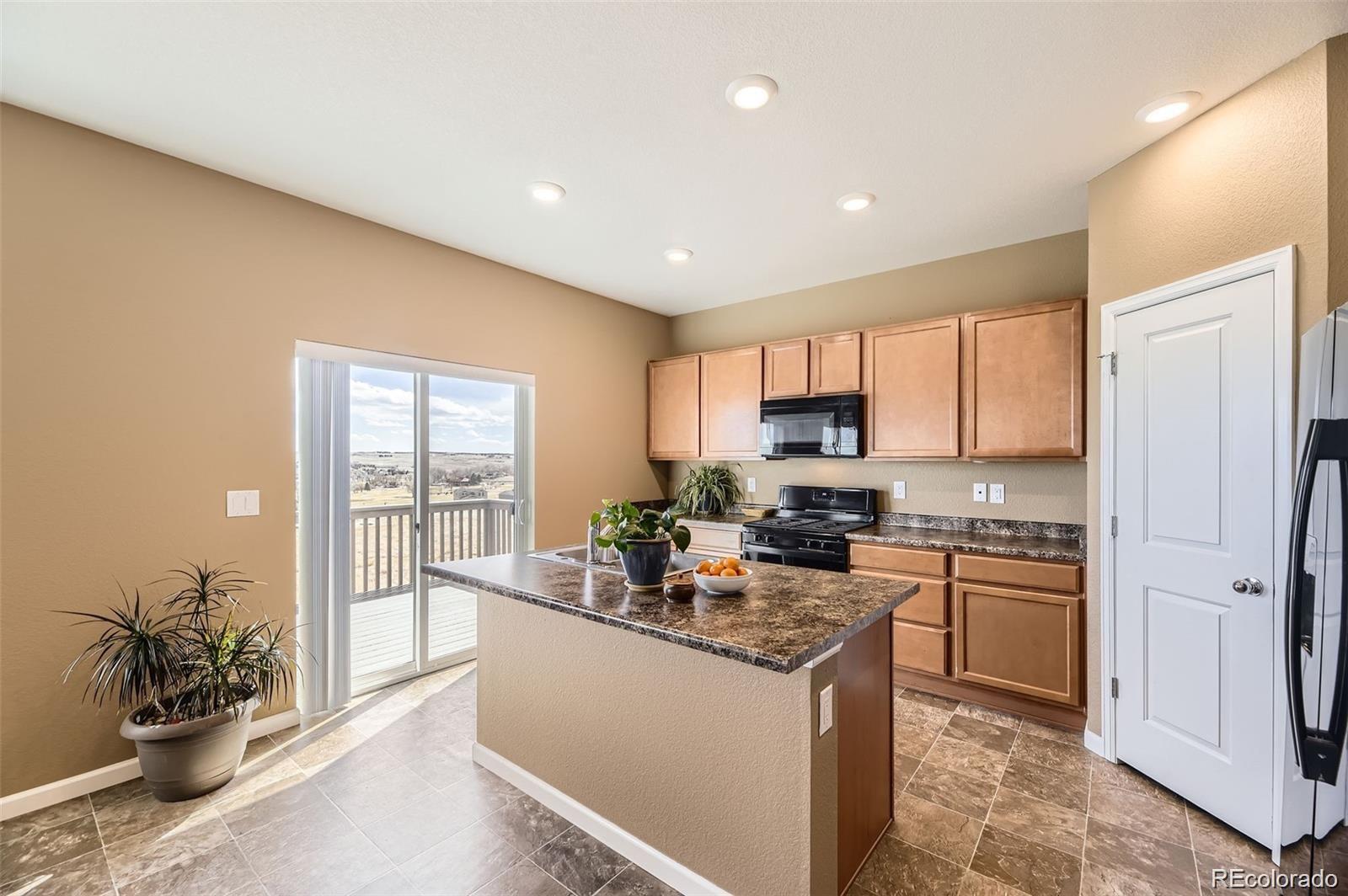 4807 River Highlands Loop Elizabeth, CO 80107 - Photo 5 of 37 a kitchen with a refrigerator and a sink