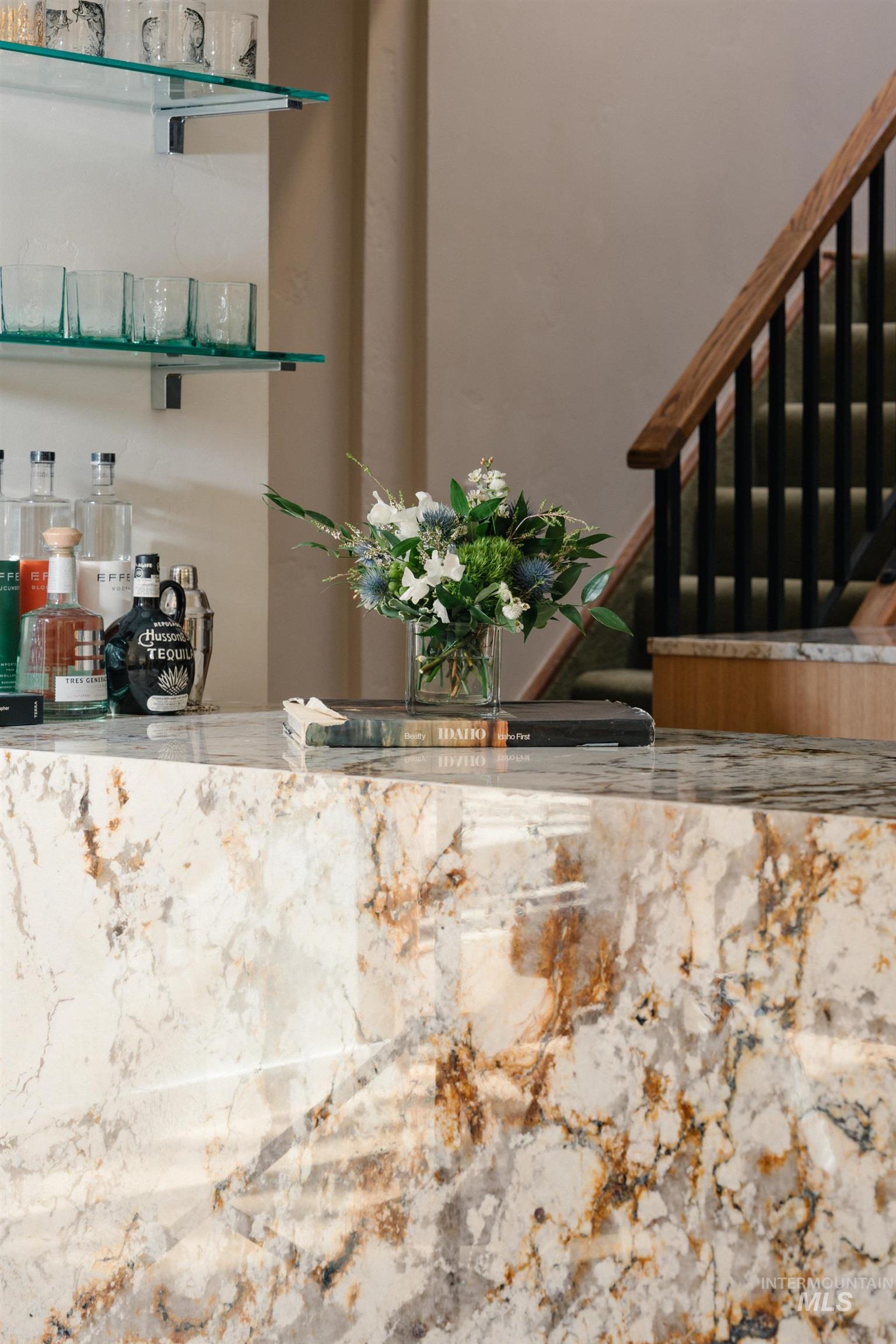 208 Georginia Road, Unit A Ketchum, ID 83340 - Photo 10 of 30 Built-in bar with a polished stone countertop, complementary stone bar face, and two tiers of glass shelving