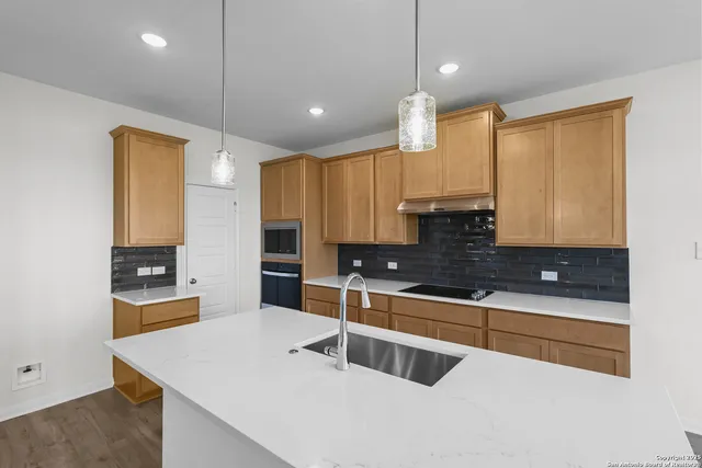 a kitchen with stainless steel appliances a sink stove and white cabinets
