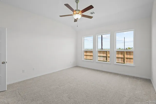 an empty room with a window and a ceiling fan