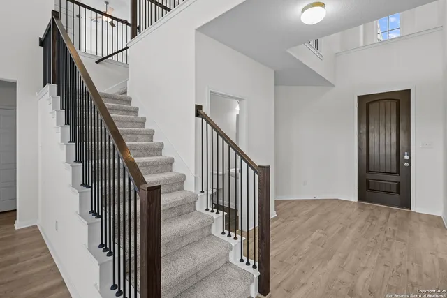 a view of a hallway with wooden floor and entryway