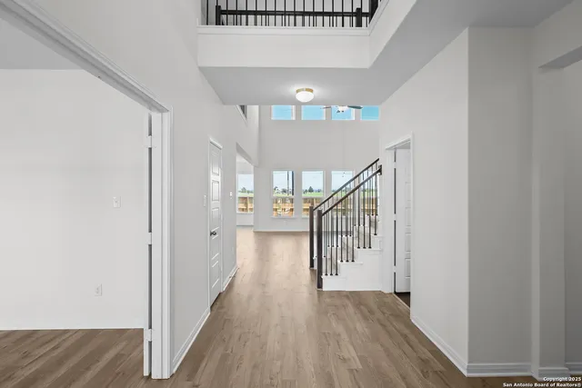 a view of a hallway with wooden floor and staircase