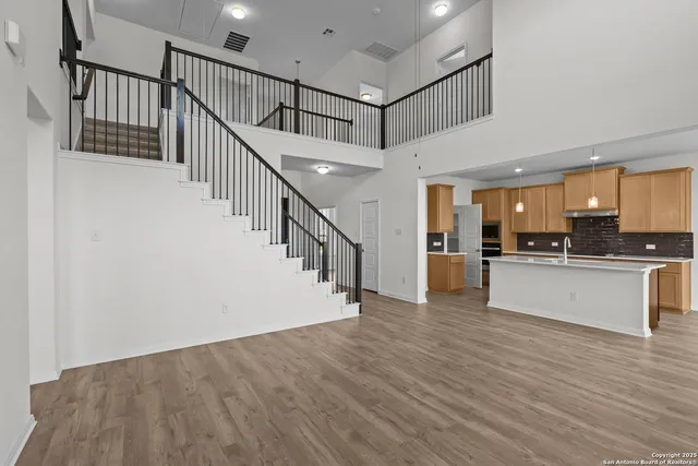 a view of a kitchen with wooden floor and electronic appliances