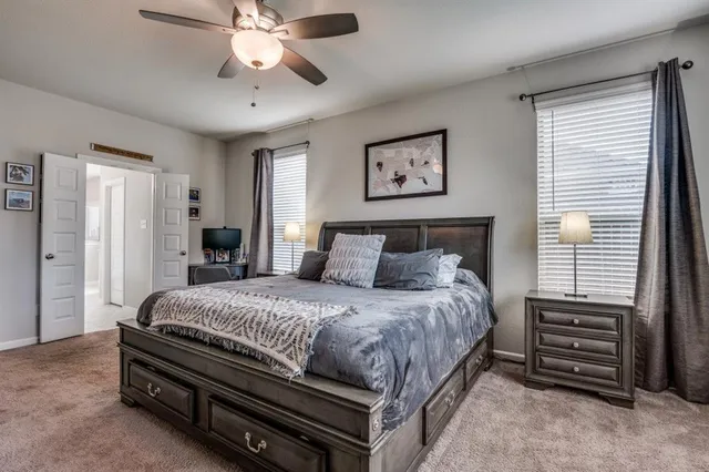 a spacious bedroom with a bed and a flat screen tv