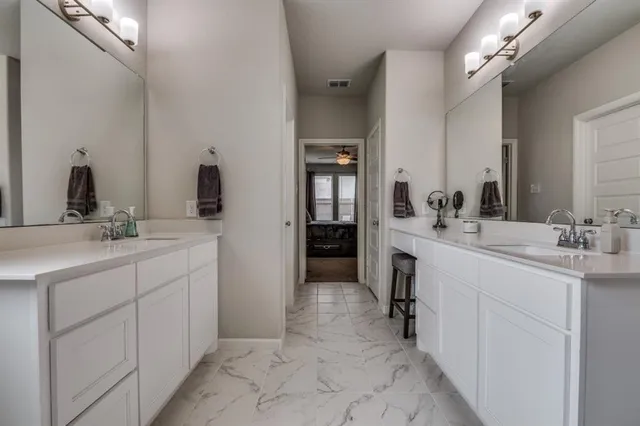 a spacious bathroom with a double vanity sink and mirror
