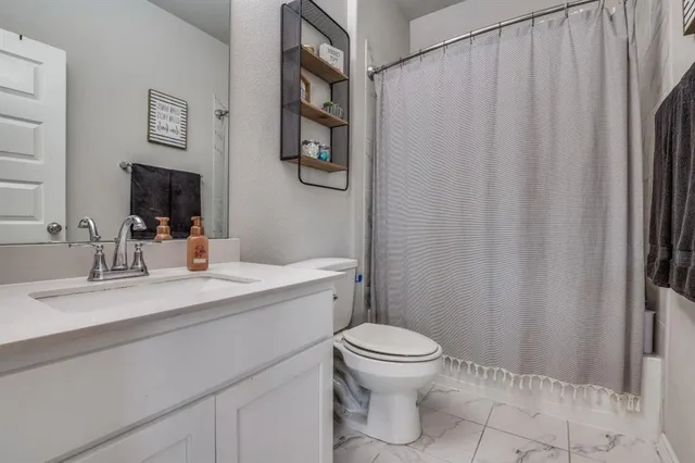 a bedroom with a bed and a dresser next to a window