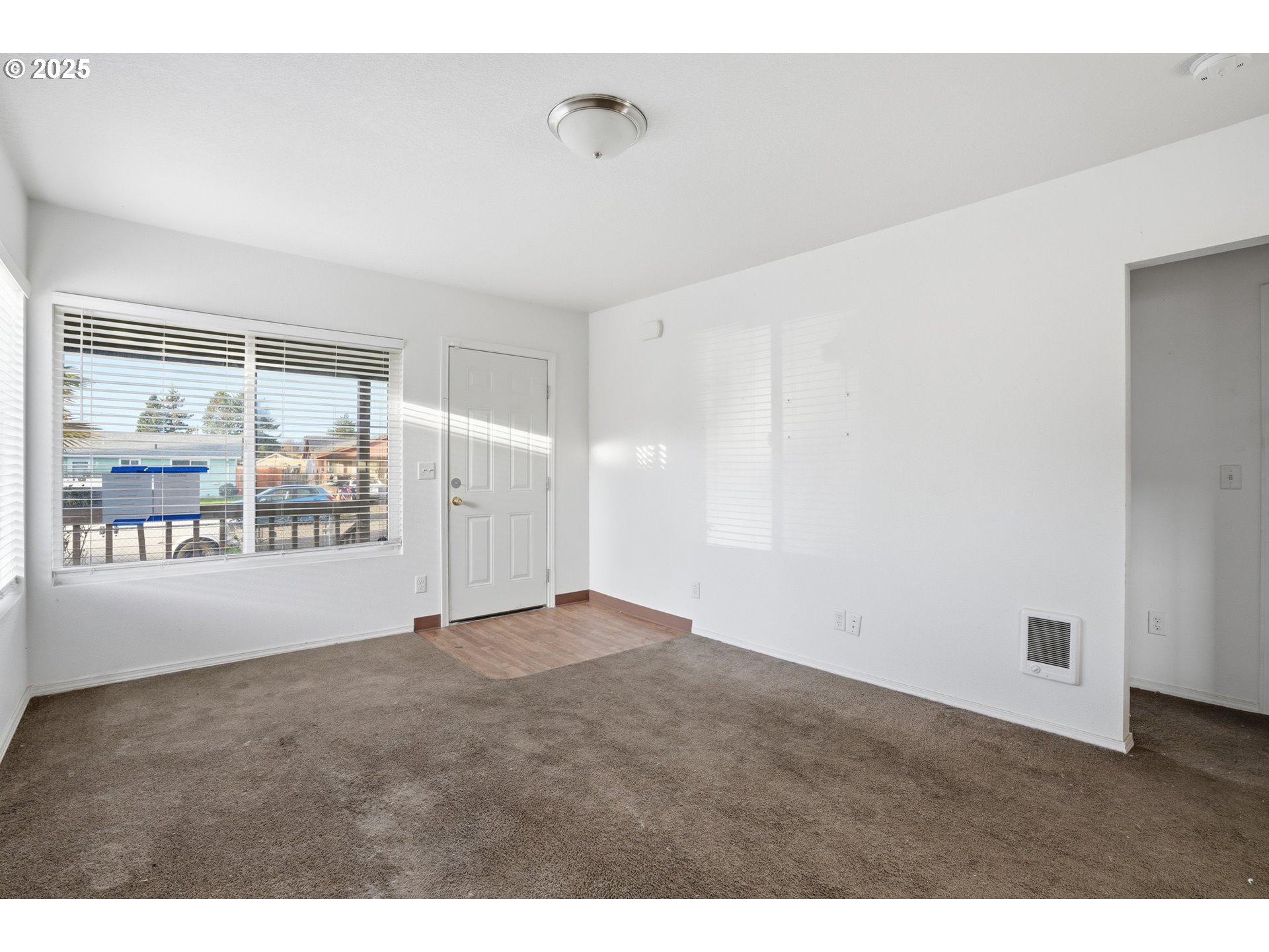 344 Douglas Street Longview, WA 98632 - Photo 8 of 29 a view of an empty room with wooden floor and windows