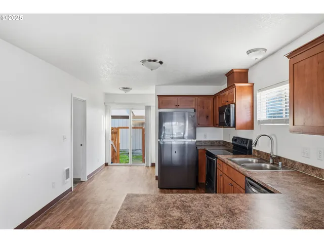 a kitchen with stainless steel appliances granite countertop a refrigerator and a sink