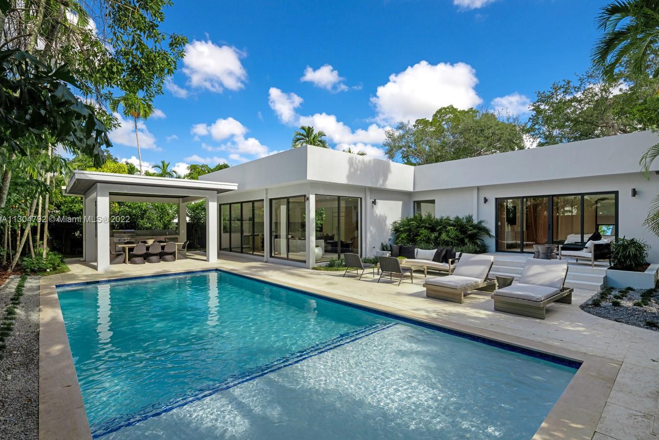 a view of a house with swimming pool and sitting area