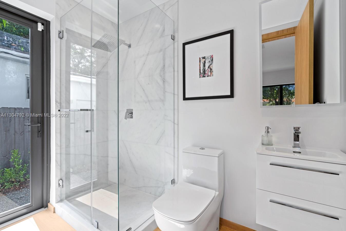 10 Pinta Road Miami, FL 33133 - Photo 25 of 52 a bathroom with a toilet sink and a mirror