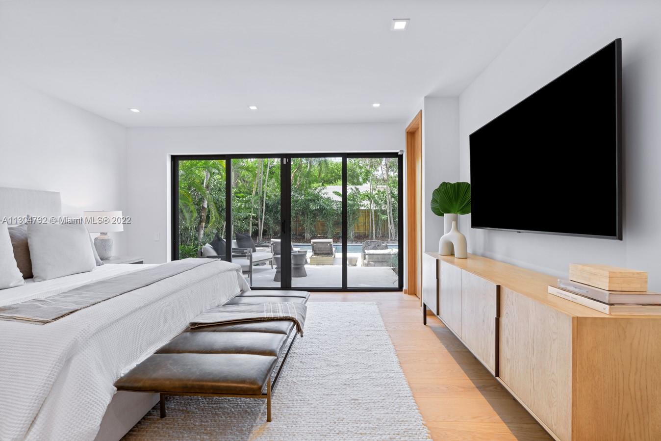 10 Pinta Road Miami, FL 33133 - Photo 26 of 52 a spacious bedroom with a large bed and a flat screen tv