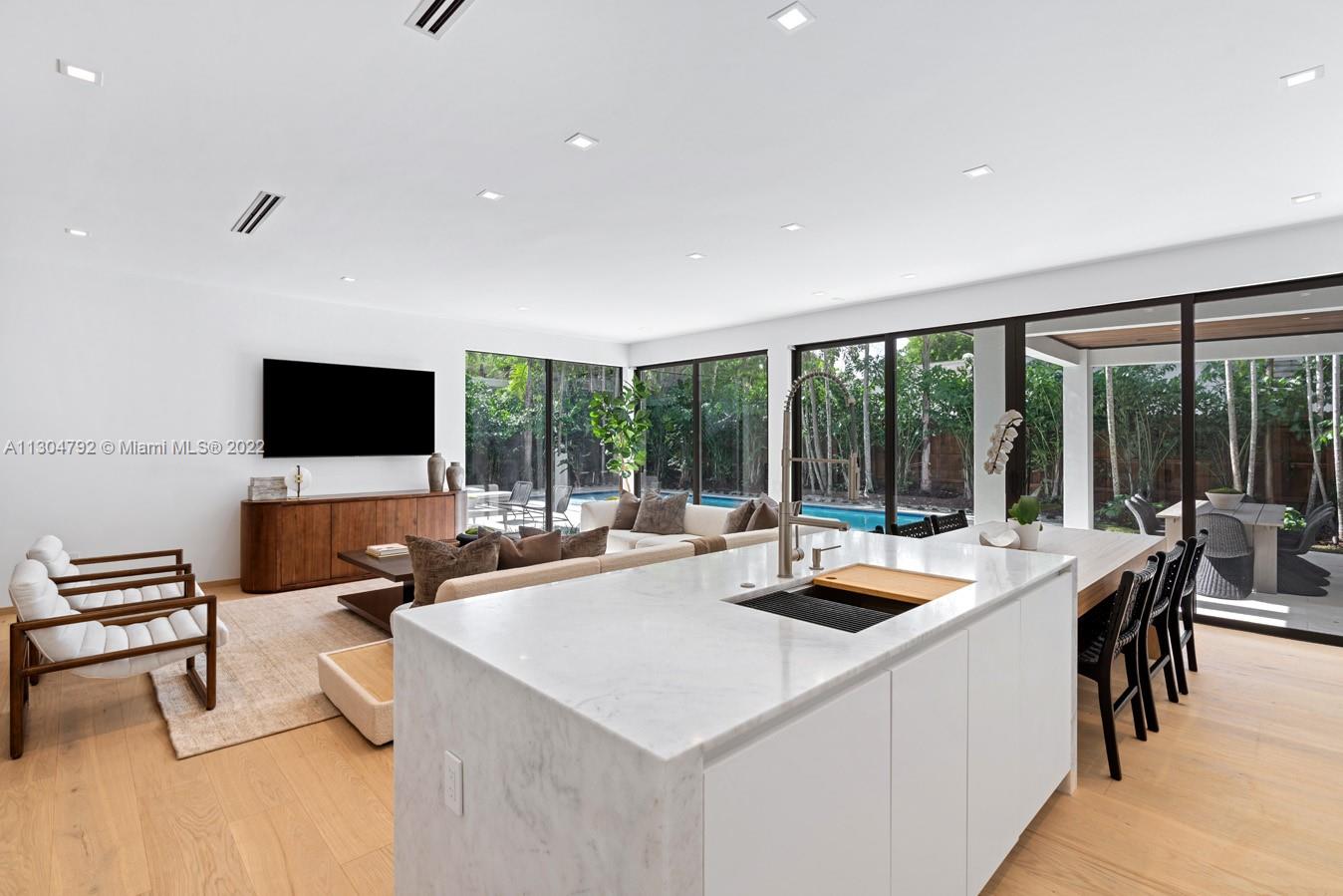 10 Pinta Road Miami, FL 33133 - Photo 41 of 52 a view of a dining area with furniture large windows and a flat screen tv
