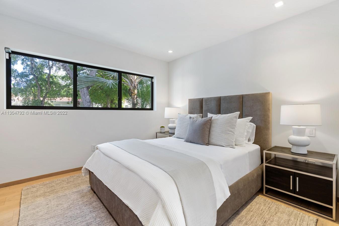 10 Pinta Road Miami, FL 33133 - Photo 44 of 52 a bedroom with a bed and a lamp next to a window