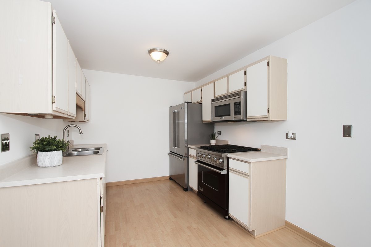 400 Woodview Circle, Unit A Elgin, IL 60120 - Photo 15 of 40 a kitchen with microwave a stove and cabinets