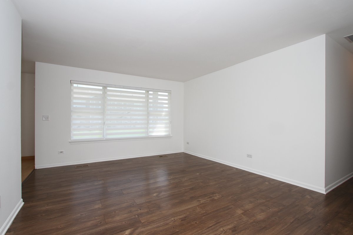 400 Woodview Circle, Unit A Elgin, IL 60120 - Photo 5 of 40 a view of an empty room with wooden floor and a window