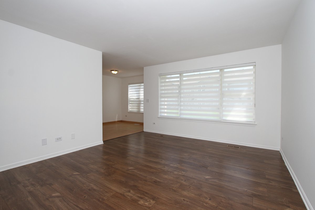 400 Woodview Circle, Unit A Elgin, IL 60120 - Photo 6 of 40 a view of an empty room with wooden floor and a window