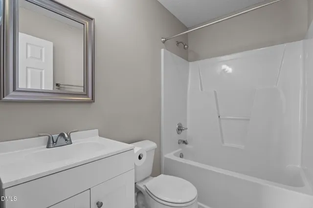 a bathroom with a sink toilet vanity and tub