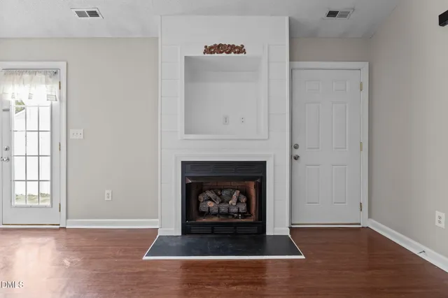 an empty room with fireplace and wooden floor