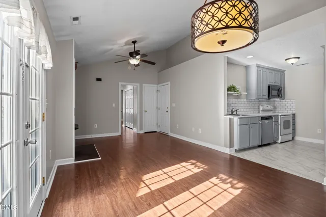 a view of kitchen with granite countertop a stove a sink and a wooden floor