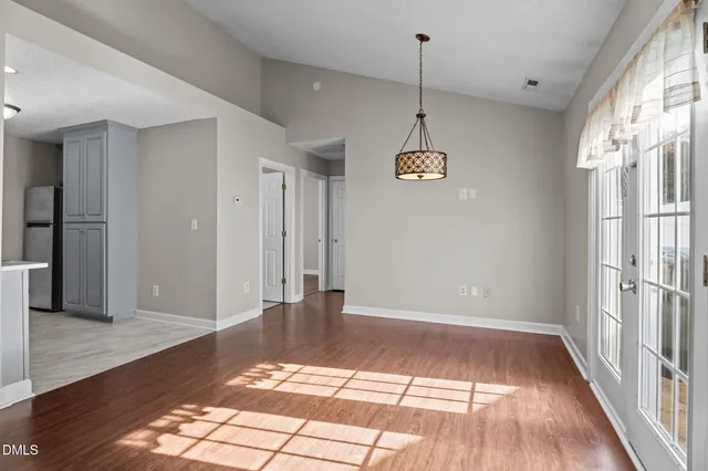 a view of a room with wooden floor and a window