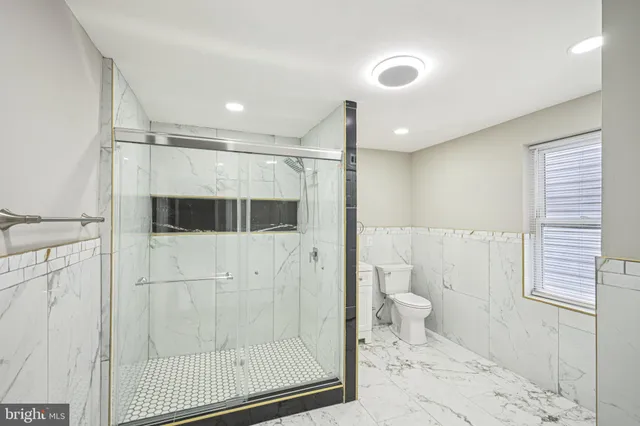 a bathroom with a toilet a sink and shower