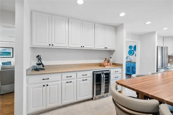 a kitchen with white cabinets and sink