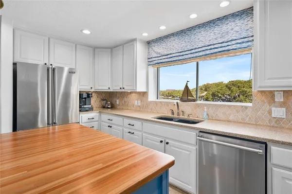 a kitchen with stainless steel appliances a sink stove and refrigerator