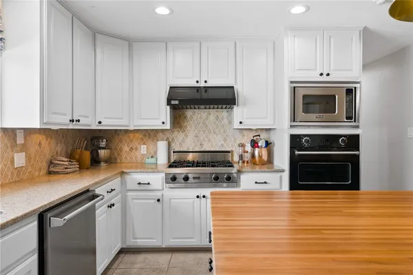 a kitchen with stainless steel appliances granite countertop a stove and cabinets