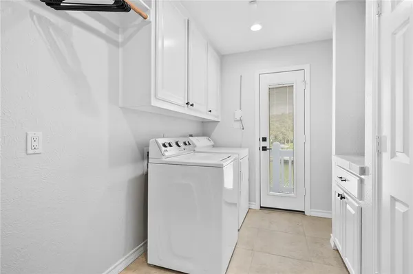 a utility room with cabinets washer and dryer