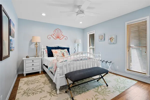 a bedroom with a bed a rug and wooden floor