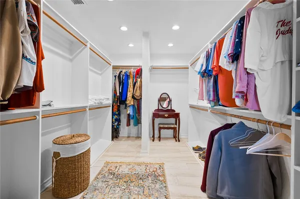a view of walk in closet with clothes and shoes