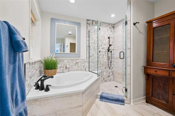 a bathroom with a tub sink and mirror