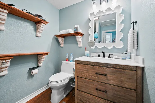 a bathroom with a granite countertop toilet sink and mirror