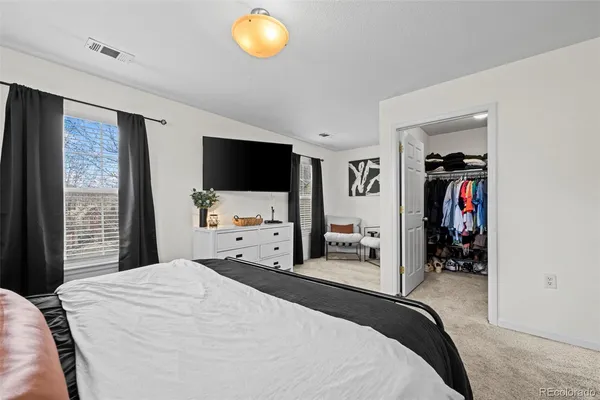 a bedroom with a bed and a flat tv screen