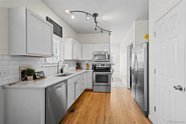 a kitchen with stainless steel appliances a refrigerator sink and microwave