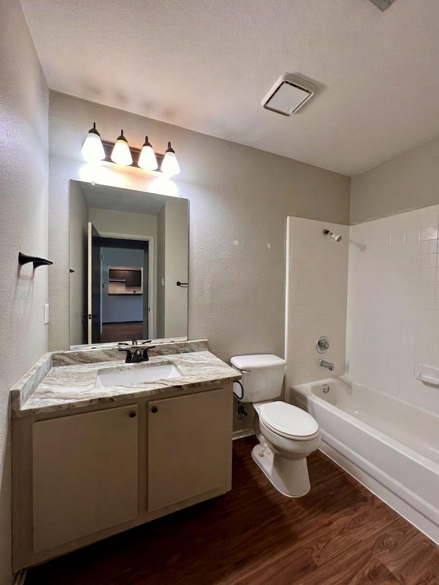 5404 China Berry Road Austin, TX 78744 - Photo 17 of 20 A well-appointed bathroom features a practical vanity with a sink, a toilet, and a combined shower-bathtub unit.