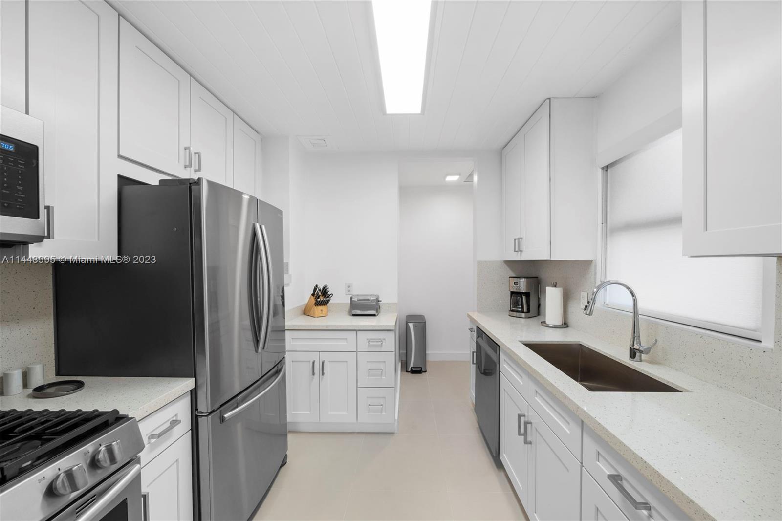 8844 Abbott Avenue Surfside, FL 33154 - Photo 8 of 11 a kitchen with stainless steel appliances a sink stove refrigerator and cabinets